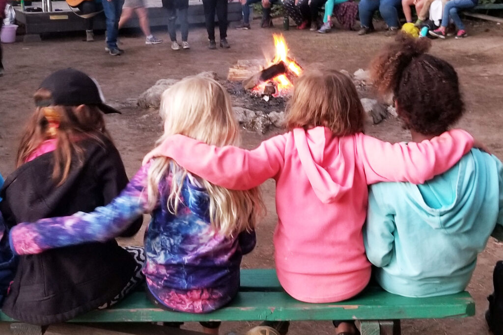 girls sitting together at the campfire